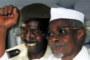 Hissène Habré L'ancien président tchadien Hissène Habré lève le poing en signe de victoire alors qu'il quitte un tribunal de Dakar, escorté par un policier sénégalais le 18 novembre 2005